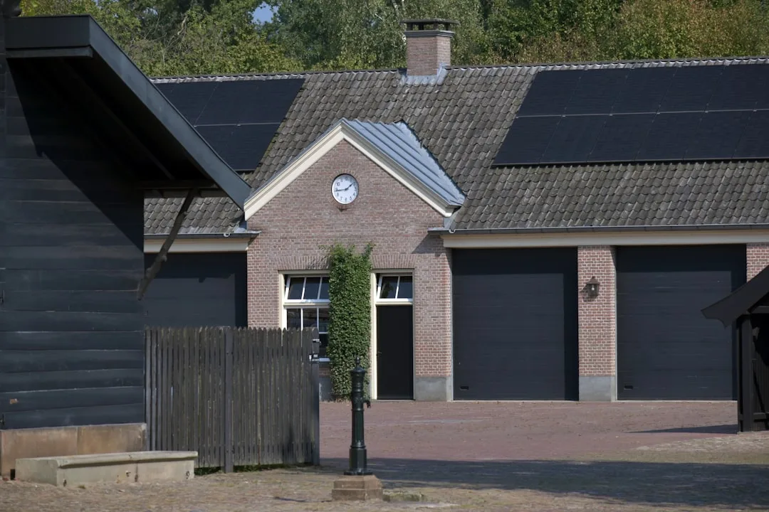 Zonnepanelen op dak — A house with a fence and a clock on the front of it